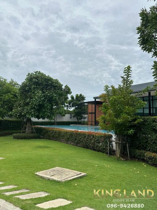 Outdoor area with a pool and manicured lawn