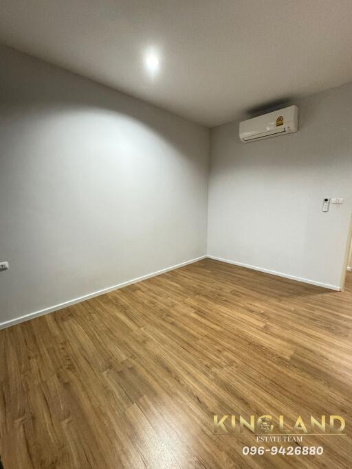 Empty bedroom with wooden flooring and air conditioner