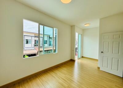 Spacious bedroom with large window and wooden flooring