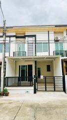 Facade of a modern two-story house with balcony and covered porch.