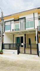 Modern two-story building with gated entrance and parking area