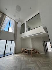 Spacious living room with high ceiling and large windows