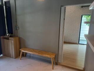 Minimalist living area with wooden bench and open doorway