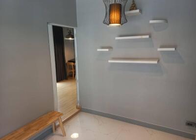 Minimalist entryway with shelving and wooden bench