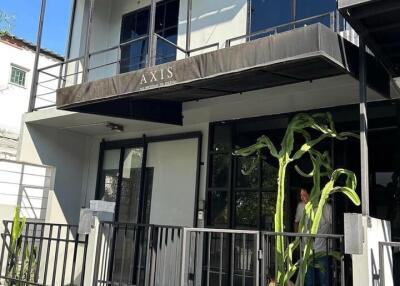 Modern two-story building exterior with balcony and gated entrance