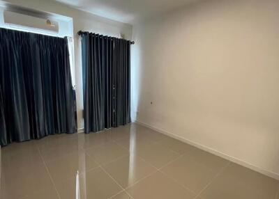 Empty bedroom with tiled floor and dark curtains