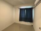 Empty bedroom with tiled floor and window with curtains