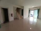 Spacious living room with staircase and large glass doors