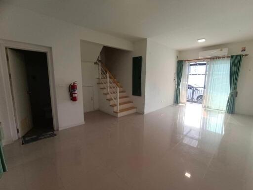 Spacious living room with staircase and large glass doors