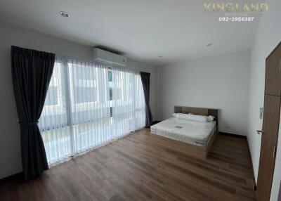 Spacious bedroom with large windows and curtains