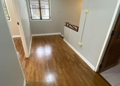 Well-lit hallway with wooden flooring