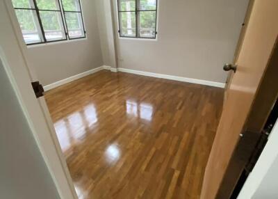 Bedroom with wooden flooring and large windows