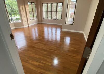 Spacious bedroom with wooden floors and large windows