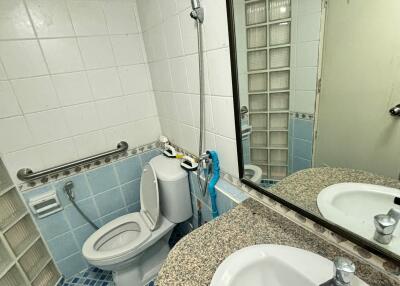 Small bathroom with tiled walls, a round vanity sink, and a toilet.