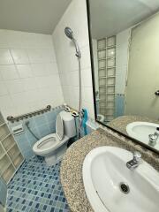 Small bathroom with tiled walls, a round vanity sink, and a toilet.