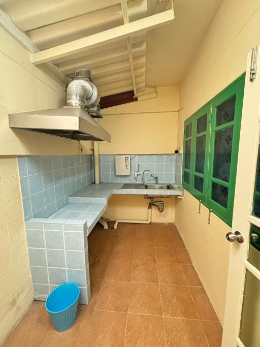 Simple kitchen with tiled countertops and a sink