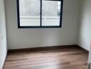 Unfurnished bedroom with wooden floor and window