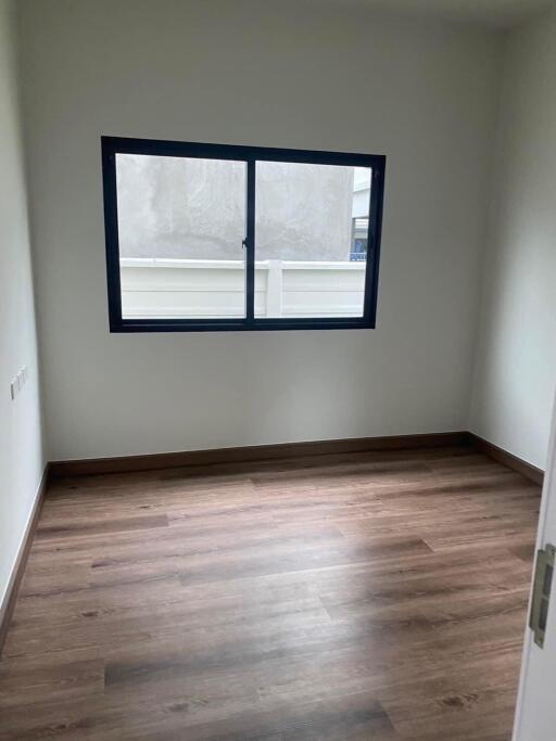 Unfurnished bedroom with wooden floor and window