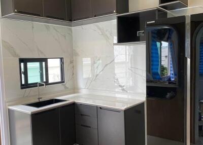 Modern kitchen with dark cabinets and marble backsplash