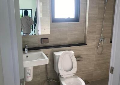 Modern bathroom with a toilet, sink, and shower