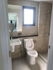 Modern bathroom with a toilet, sink, and shower