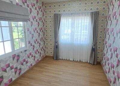 Colorful room with patterned wallpaper and wooden flooring