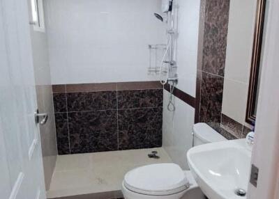 Modern bathroom with white fixtures and dark tile accents