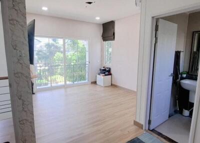 Spacious upstairs living area with large window and adjacent bathroom