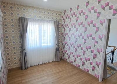 Small bedroom with patterned wallpaper and window