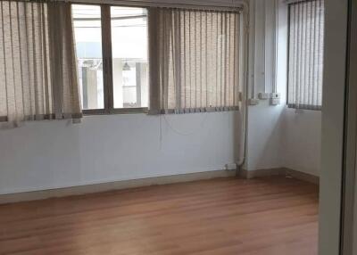 Empty bedroom with wooden flooring and large windows