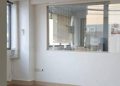 Empty office space with wooden floor and large windows