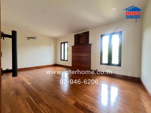 Spacious living room with hardwood floors and large windows