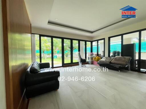 Spacious living room with large windows and comfortable seating