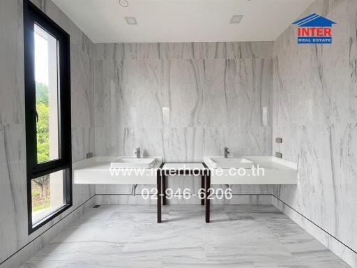 Spacious bathroom with marble walls and double sinks