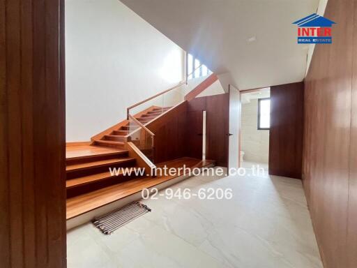 Staircase area with wooden steps and glass railing