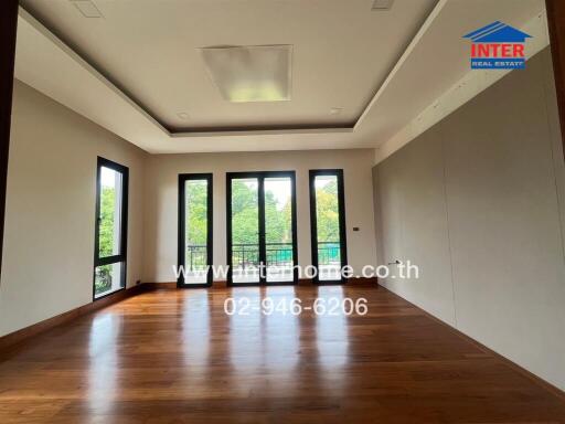 Spacious living room with wooden floor and large windows