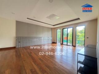 Spacious living area with large windows and hardwood flooring