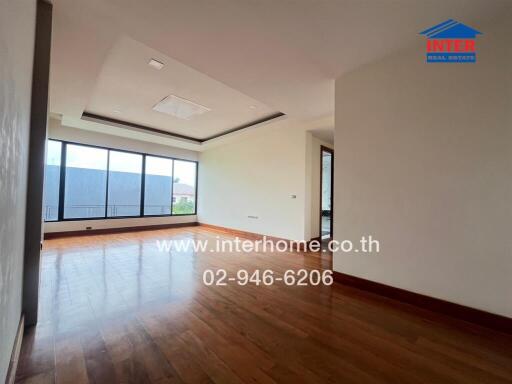 Spacious living room with large windows and hardwood floors