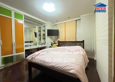 Spacious bedroom with large bed, television, and wardrobe