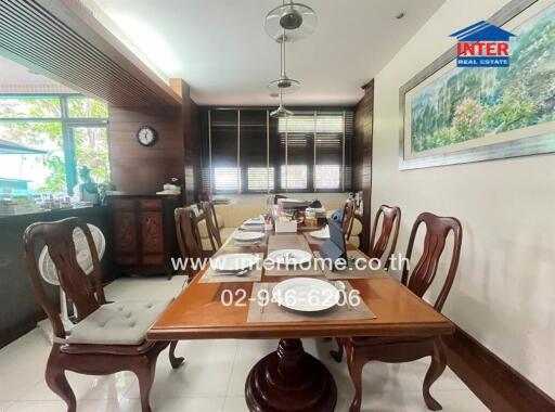 Dining room with table set for meal and wooden chairs