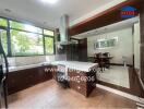 Modern kitchen with a dining area overlooking greenery through large windows