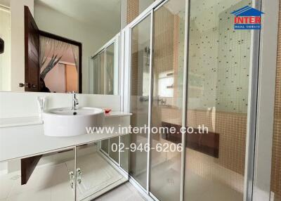 Modern bathroom with glass shower enclosure and vanity mirror