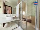 Modern bathroom with glass shower enclosure and vanity mirror