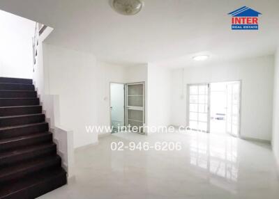 Spacious white living area with staircase