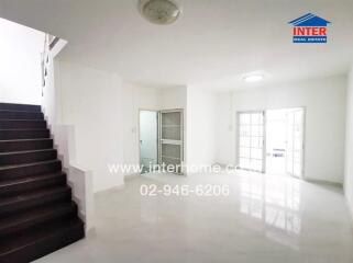 Spacious white living area with staircase