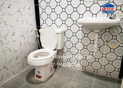 Bathroom with wall tiles, toilet, and sink