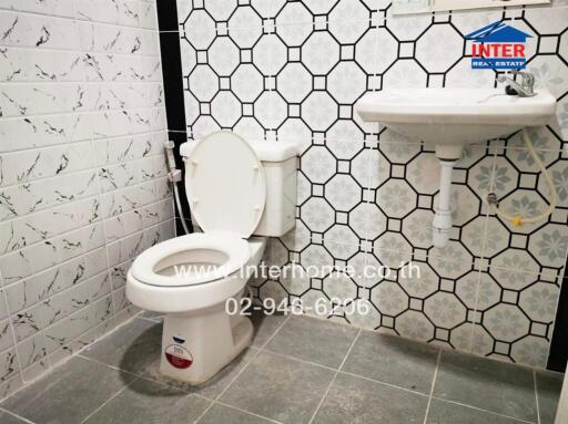 Bathroom with wall tiles, toilet, and sink