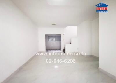 Empty Living Area with Staircase and Tile Flooring