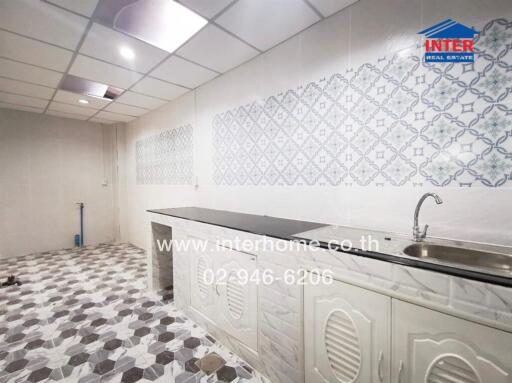 Clean kitchen space with a tiled backsplash and flooring