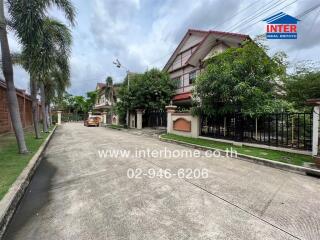 Street view of residential houses with trees and parked cars